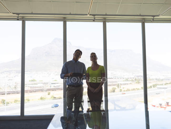 Вид спереди на природу кавказский мужчина и кавказская блондинка архитекторы взаимодействуют друг с другом в офисе — стоковое фото