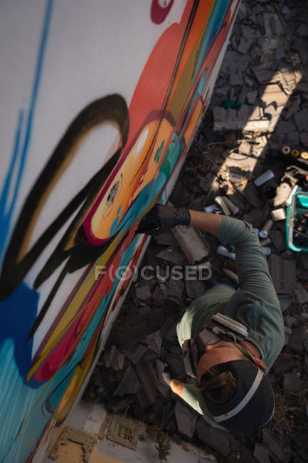 Висока кут зору молодого художника графіті кавказьких почерпнуті з маркером вивітрюванню стіни — стокове фото