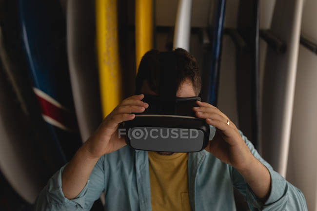 Front view of Caucasian man holding virtual reality headset in a workshop — Stock Photo