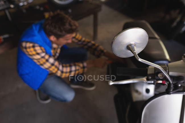 Vista de ángulo alto de la bicicleta caucásica mecánico reparación de bicicletas en el garaje - foto de stock