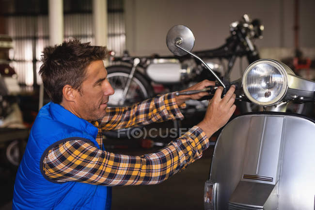 Seitenansicht eines kaukasischen Fahrradmechanikers, der Fahrrad in Garage repariert — Stockfoto