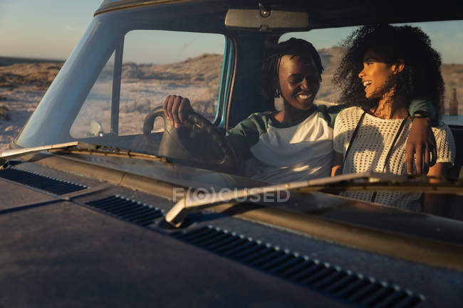 Frontansicht eines romantischen jungen afrikanisch-amerikanischen Paares, das sich an einem sonnigen Tag im Auto entspannt — Stockfoto