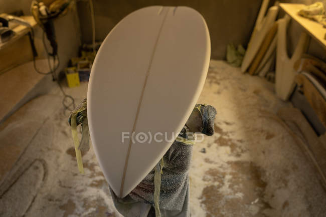 Nouvelle planche de surf sur un stand de réparation en atelier — Photo de stock