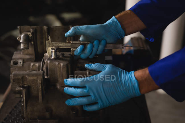 Seitenansicht eines Fahrradmechanikers, der einen Fahrradmotor in der Garage repariert — Stockfoto