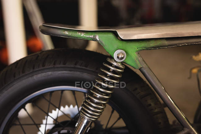 Close up of motor bike seat and tire in garage — Stock Photo