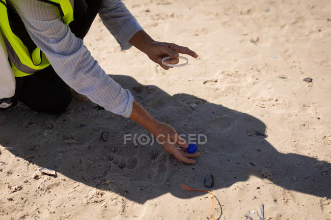Средняя секция женского волонтерского пляжа уборки в солнечный день — стоковое фото