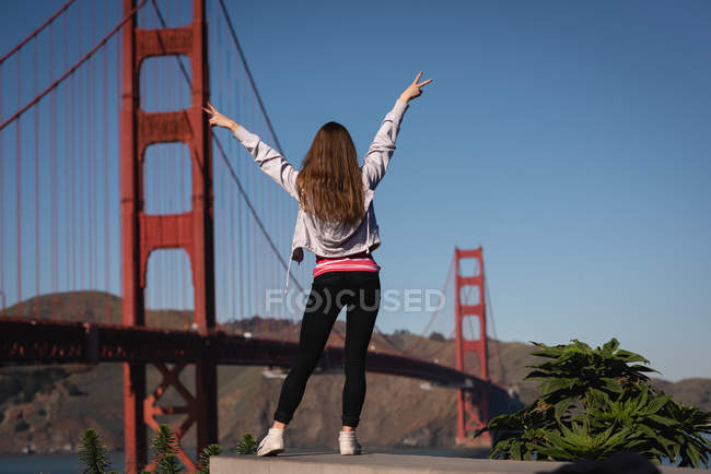 Вид ззаду красива жінка, насолоджуючись біля золотих воріт мосту — стокове фото