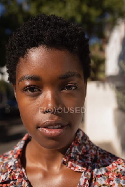 Portrait de belle jeune femme afro-américaine debout dans la rue par une journée ensoleillée — Photo de stock