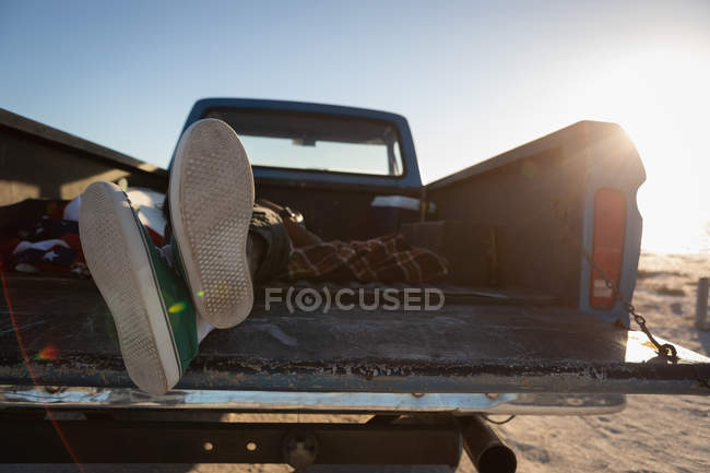 Uomo sdraiato in auto in spiaggia in una giornata di sole — Foto stock