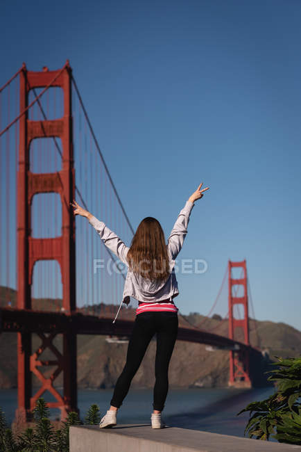 Rückansicht einer Frau, die in der Nähe der goldenen Torbrücke genießt — Stockfoto