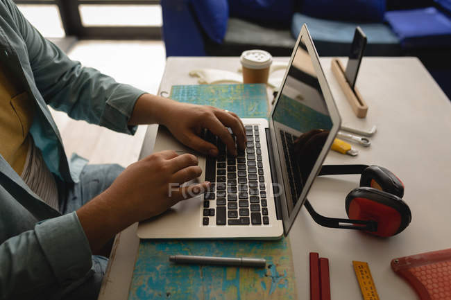 Seção média do homem usando laptop em uma oficina — Fotografia de Stock