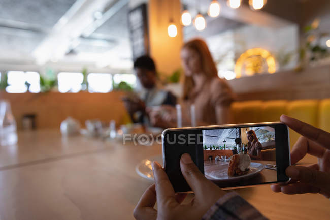 Fechar o telemóvel. Amigos do sexo feminino tirando fotos de comida de café da manhã com telefone celular no restaurante — Fotografia de Stock