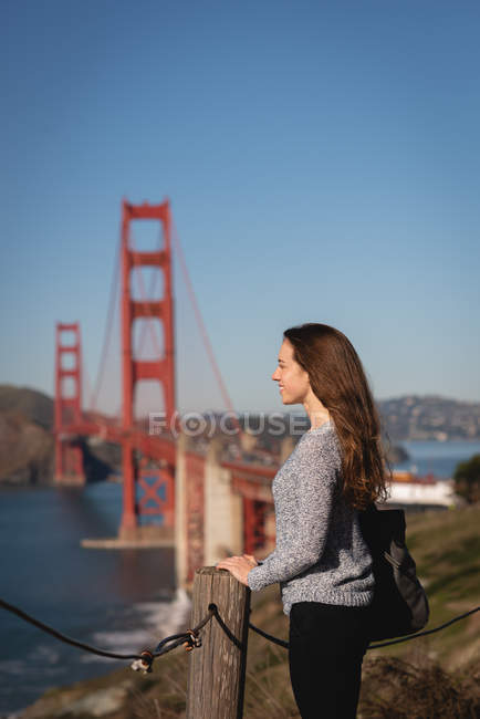 Vista lateral da bela mulher em pé perto de trilhos — Fotografia de Stock