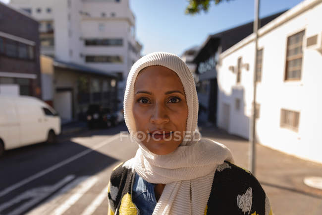 Portrait of young mixed-race woman looking at camera while standing at street on a sunny day — Stock Photo