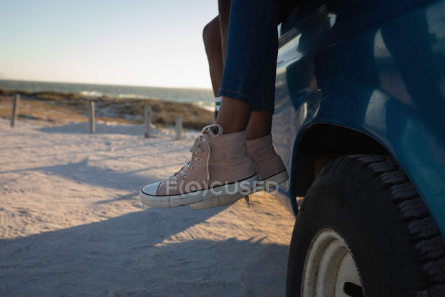 Low section of couple at beach in car on a sunny day — Stock Photo