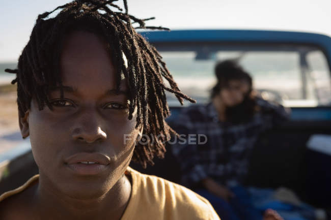Портрет молодого афроамериканського чоловіка біля своєї подруги відпочиваючи в машині на пляжі в сонячний день — стокове фото