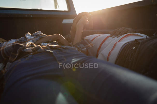 Seitenansicht eines jungen afrikanisch-amerikanischen Paares, das an einem sonnigen Tag im Auto am Strand liegt — Stockfoto