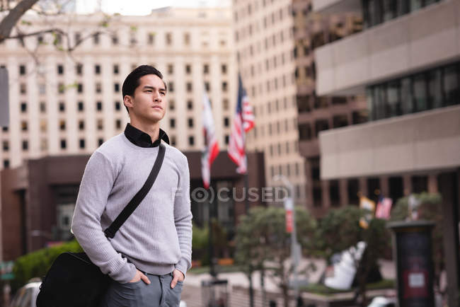 Vorderansicht eines nachdenklichen asiatischen Mannes, der auf der Straße steht — Stockfoto
