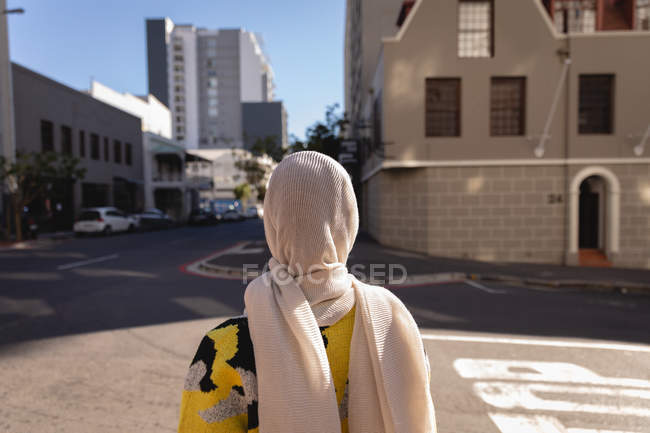 Visão traseira da mulher com hijab em pé na rua em um dia ensolarado — Fotografia de Stock