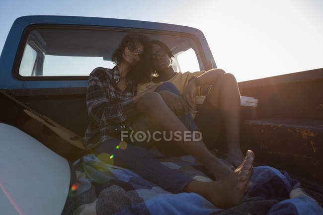 Front view of romantic couple sitting in car at beach on a sunny day — Stock Photo
