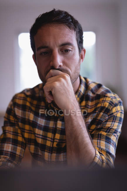 Portrait of thoughtful Caucasian male executive using laptop in the office — Stock Photo