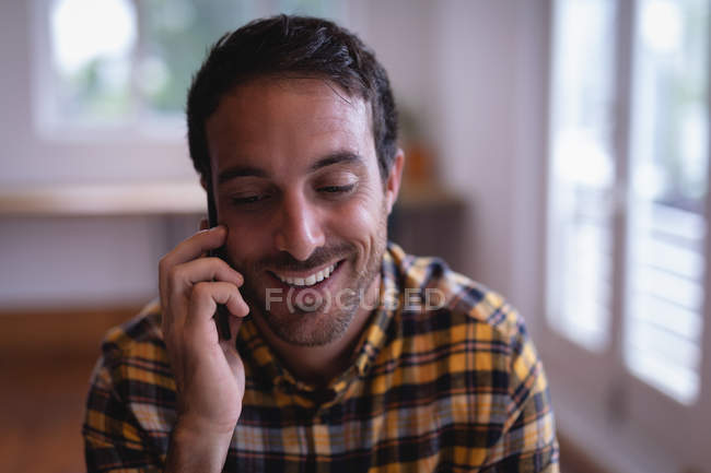 Frontansicht einer glücklichen kaukasischen männlichen Führungskraft, die mit dem Handy im Büro spricht — Stockfoto