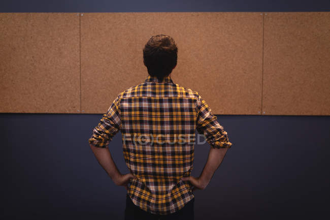 Rear view of Caucasian man executive looking at an empty board in the office — Stock Photo