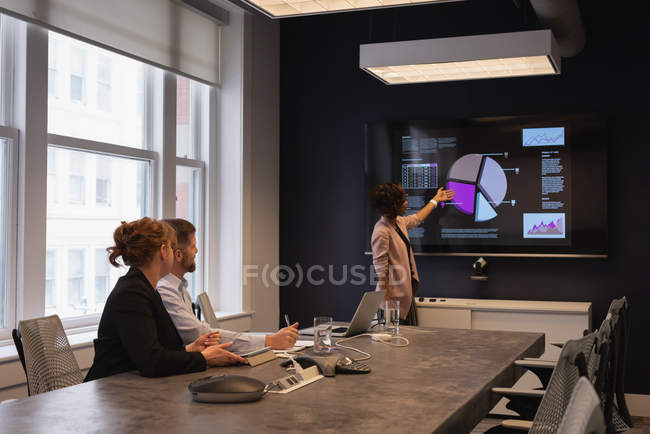 Rear view of African American businesswoman presenting new project plan to colleagues at a meeting room — Stock Photo