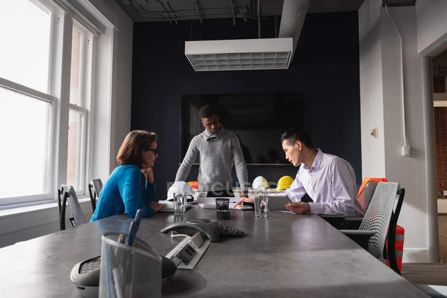 Side view of diverse architect business people working at blueprint and business plan in office — Stock Photo