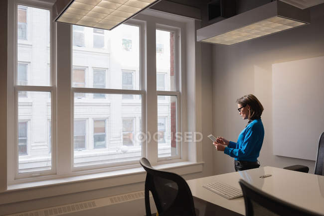 Seitenansicht einer kaukasischen Geschäftsfrau mit digitalem Tisch im Konferenzraum im Büro — Stockfoto