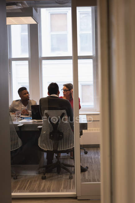 Visão traseira de diversos empresários que se reúnem na sala de conferências no escritório — Fotografia de Stock