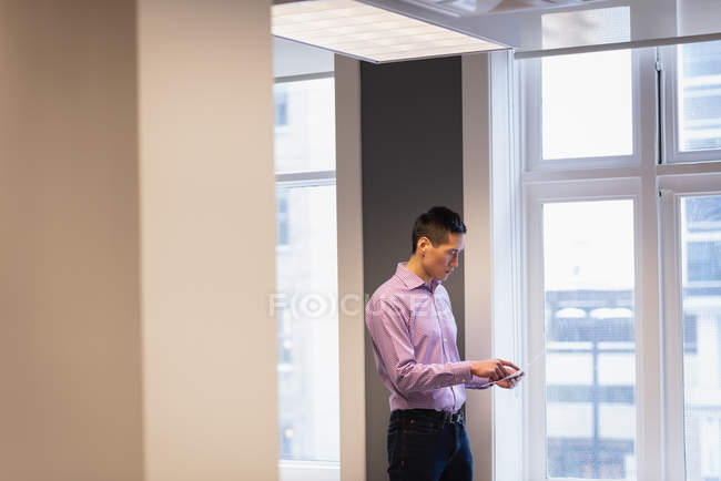 Seitenansicht eines Geschäftsmannes, der ein Foto im Büro überprüft — Stockfoto