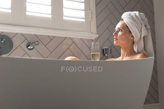 Mulher pensativa sentada na banheira no banheiro em casa — Fotografia de Stock