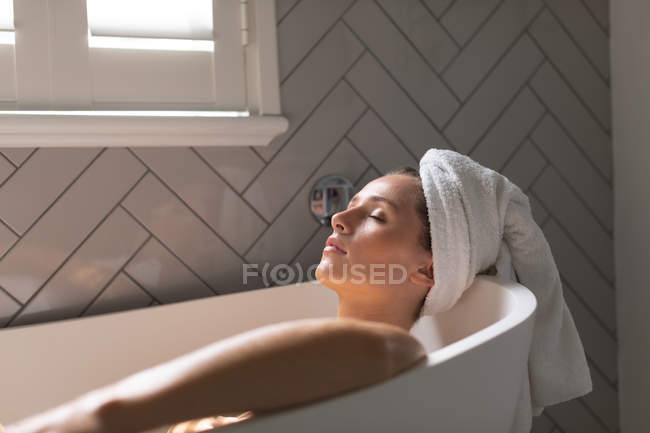 Schöne Frau entspannt sich in der Badewanne im Badezimmer — Stockfoto