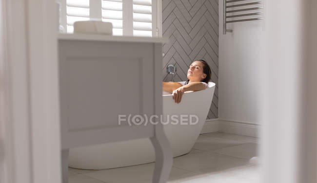 Mujer relajante en la bañera en el baño en casa - foto de stock