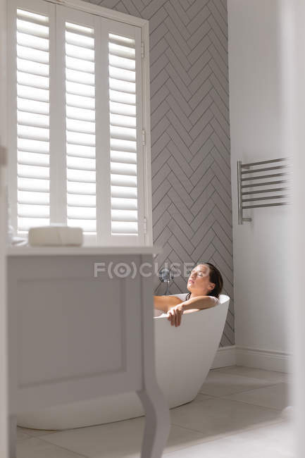 Mujer relajante en la bañera en el baño en casa - foto de stock