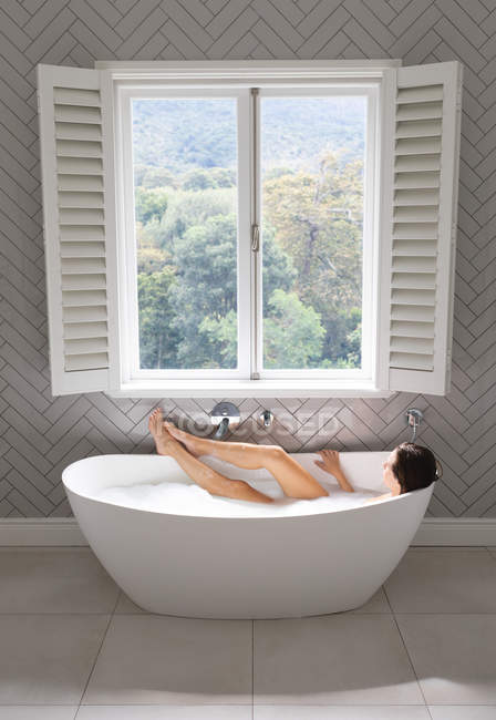 Mulher relaxante na banheira no banheiro em casa — Fotografia de Stock