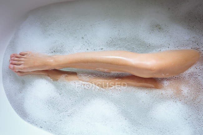 Gros plan sur les jambes sexy de la femme dans la baignoire — Photo de stock