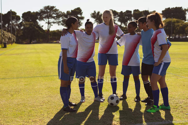 Front view of diverse female soccer players getting ready to play soccer at sports field on a sunny day. — Stock Photo