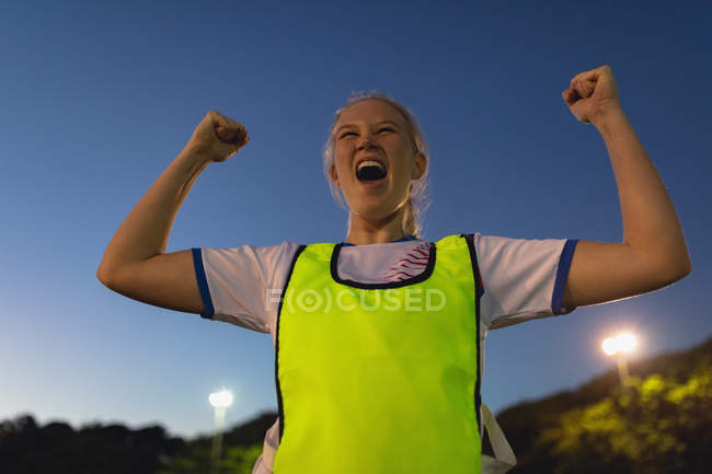 Vista basso angolo di spensierato giocatore di calcio femminile caucasico tifo dopo la vittoria al campo sportivo — Foto stock