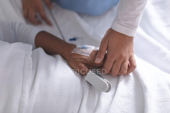 Средняя секция женщины-врача утешает пациентку в палате больницы — стоковое фото