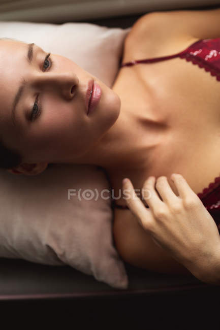 Close-up da mulher caucasiana deitada no assento da janela em casa — Fotografia de Stock
