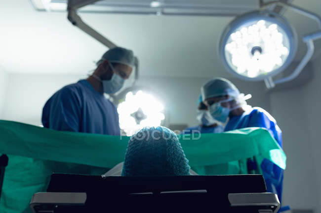 Низький кут зору різноманітної медичної команди вивчення вагітної жінки під час пологів в операційний театр в лікарні — Stock Photo