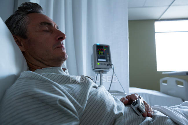 Side view of mature Caucasian male patient sleeping with left hand on stomach in the ward in hospital — Stock Photo