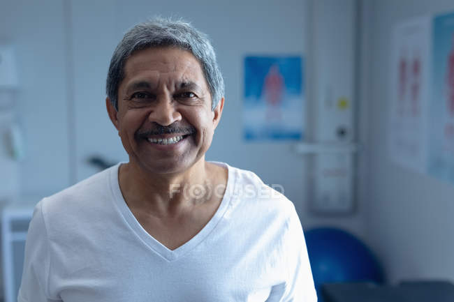 Портрет змішаної раси чоловіка-пацієнта, який посміхається в палаті в лікарні — стокове фото