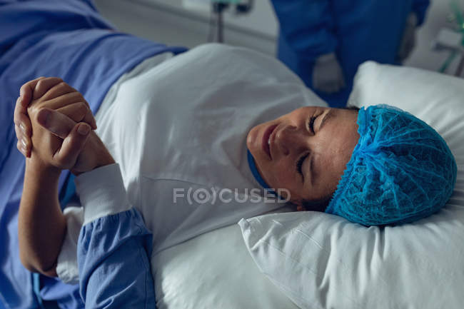 Високий погляд людини втішний вагітна жінка під час праці в операційний театр в лікарні — стокове фото