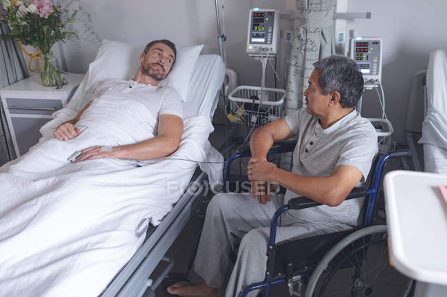 Вид на різноманітні чоловічі пацієнти, які взаємодіють один з одним у приході в лікарні. — стокове фото