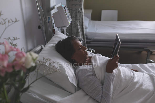 High angle view of beautiful mixed-race female patient using digital tablet in the ward at hospital. — Stock Photo