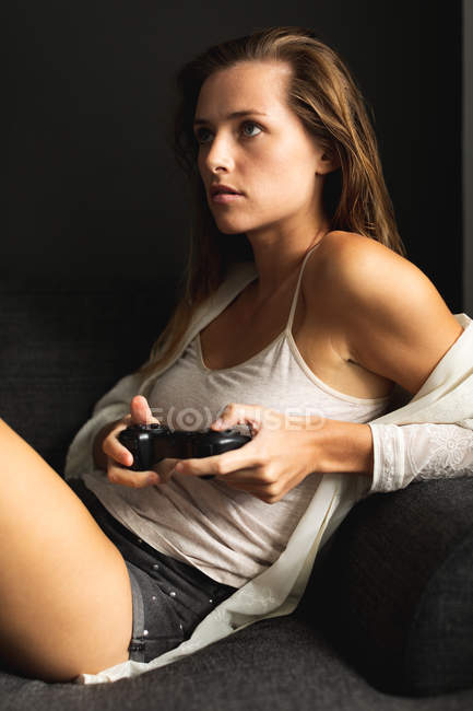 Вид збоку красива кавказька жінка грає в ігровій кімнаті в вітальні на дому — стокове фото