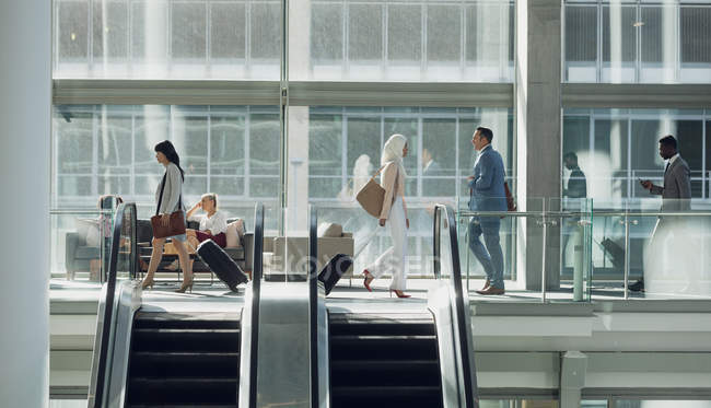 Вид сбоку на разношерстных бизнесменов, гуляющих в современном офисе — стоковое фото
